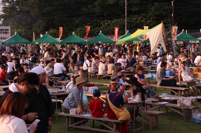 花火を見上げる祭りの参加者たち