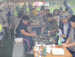 テントの下で焼き肉をする参加者たち